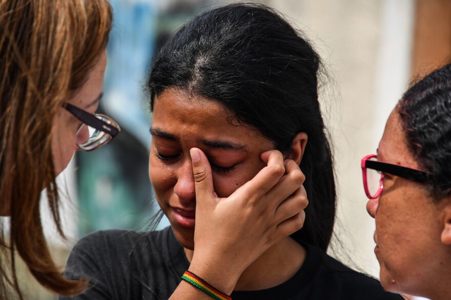 A student cries after the 2019 attack on a public school in the state of Sao Paulo, Brazil. The attack, by two former students, resulted in 10 deaths, including the attackers, who turned their weapons on themselves. It was one of the deadliest school attacks in the country's history.