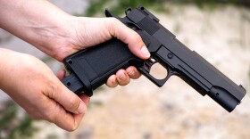 Close up, we see a hand reloading an airsoft gun