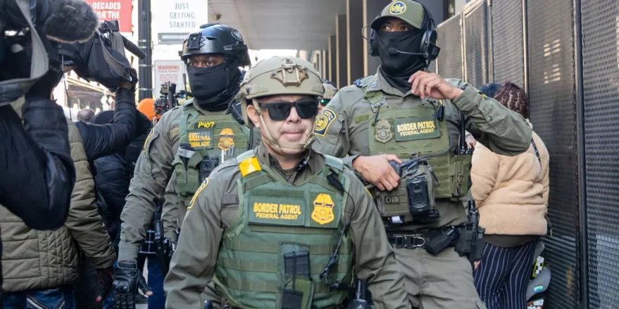 Members of the United States Border Patrol walk out of the Dirksen federal courthouse in Chicago through a sea of reporters and protesters on Oct. 28, 2025.