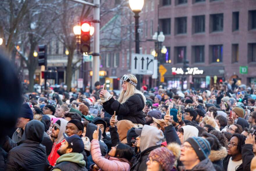 A spectator wearing ski googles snaps a picture of the 2026 Red Bull Heavy Metal Finals. (Artemisia Luk/WBUR)