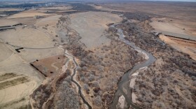 A river is seen running through a large land terrain from above ground.