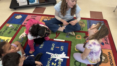Kindergarten teacher Jacqueline Gleason-Boure talks with Josephine Ziniti during a math lesson at Weston Elementary School in Manchester. Students learn all their core subjects in French through the district's language immersion program. Other classes are learning in Spanish.