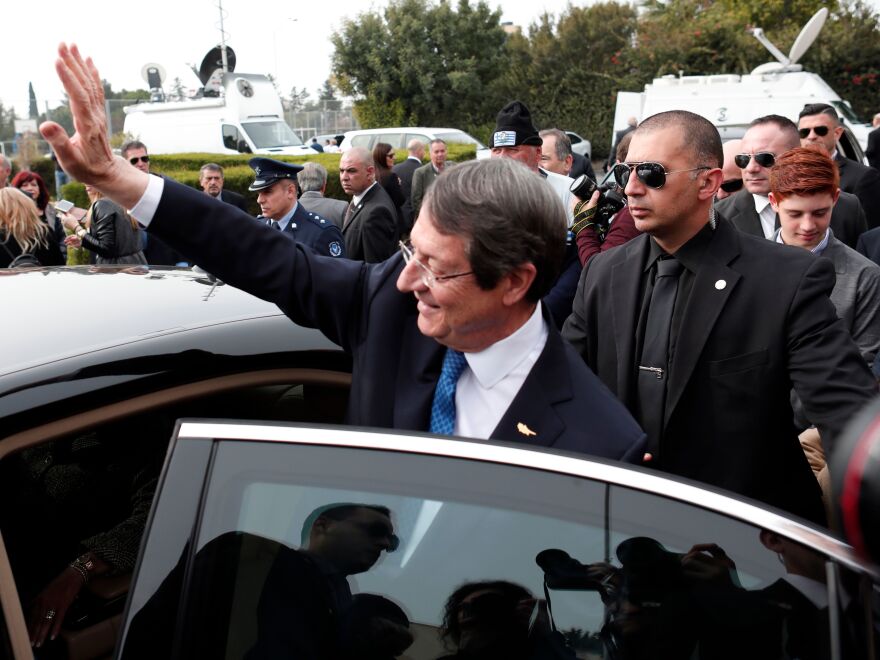 President of Cyprus Nicos Anastasiades waves to his supporters after casting his ballot at a polling station in the coastal city of Limassol on Sunday during the second round of the Cyprus presidential elections.