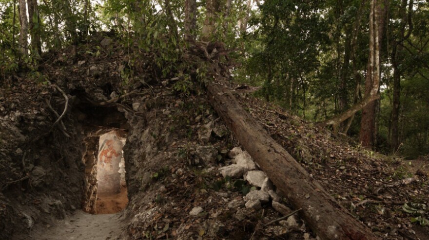 The painted figure of a man — possibly a scribe who once lived in the house built by the ancient Maya — is illuminated through a doorway to the dwelling, in northeastern Guatemala. The structure represents the first Mayan house found to contain artwork on its walls.