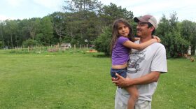 Juan De La Cruz comforts his youngest daughter, Isabella, at their home in Vergennes. (Kathleen Masterson/VPR)