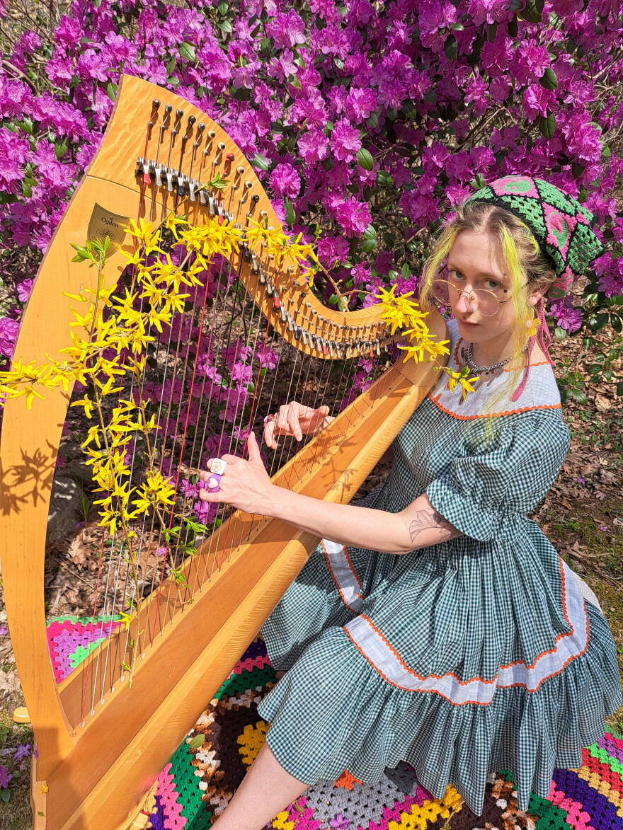 Emma Newton and their harp, the signature sound to "Space Cowboy Newt"