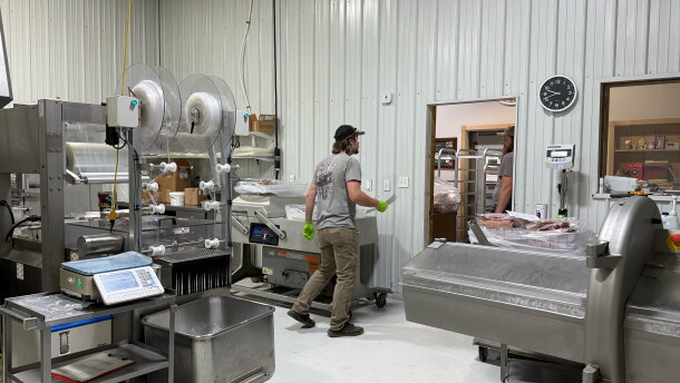 Ryan Freman is speaking to Trey Freman in their processing facility. There are several different processing machines arond.
