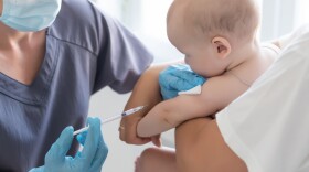 Pediatrician makes vaccination to small boy.