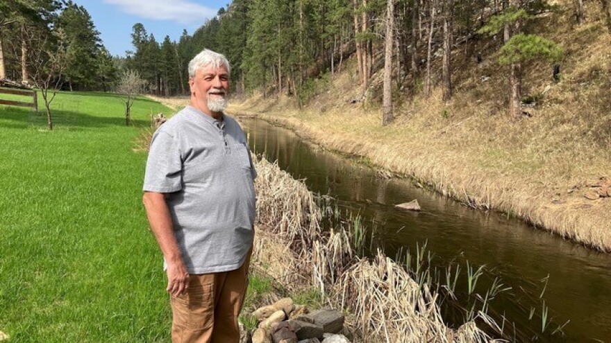 Neil Schanzenbach stands in the backyard he and his wife, Jill, own along French Creek near Custer