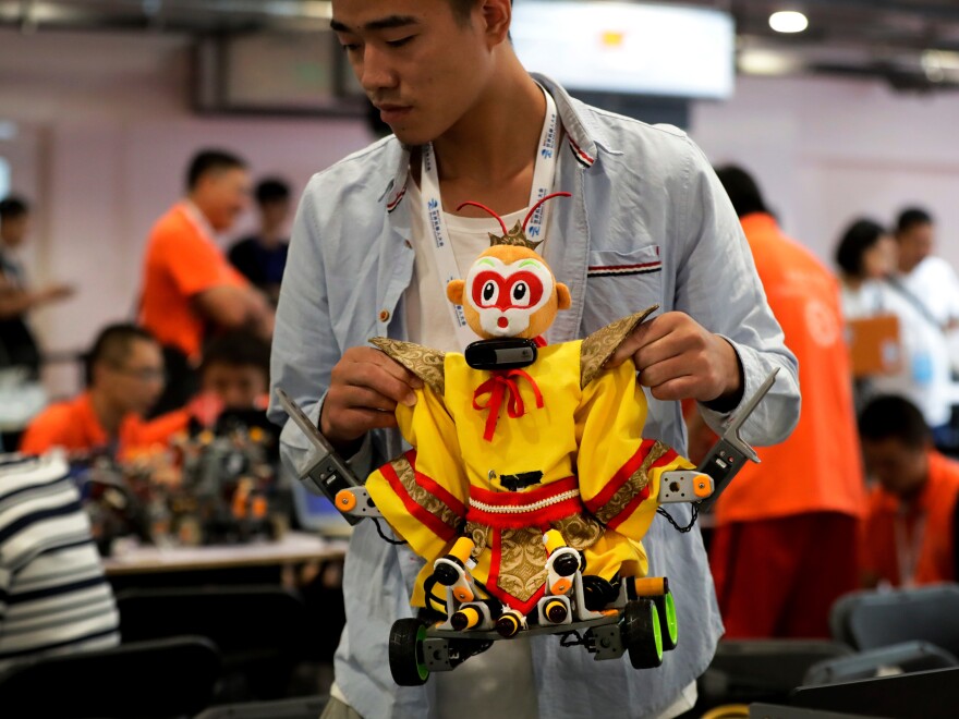 A college student carries his robot depicting the Chinese mythical Monkey King for a competition at the World Robot Conference last August in Beijing.