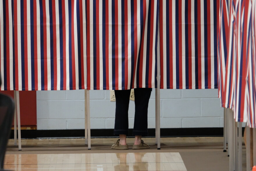 A voter filling out their ballot behind the patriotic curtain at Rye Elementary School on Sept. 8, 2026.