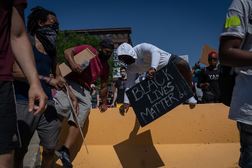 A demonstrator hops over a barrier near the St. Louis Metropolitan Police headquarters Sunday, June 7, 2020.