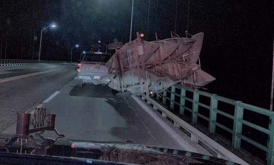 Pickup truck with tipped-over trailer on the Mackinac Bridge.