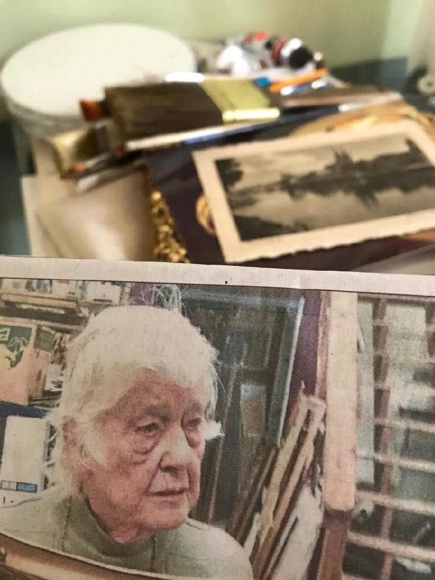 A picture of an elderly woman and her art supplies