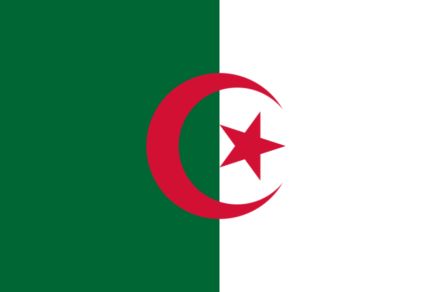 A photograph of the Algerian national flag flying with a bright blue sky background.