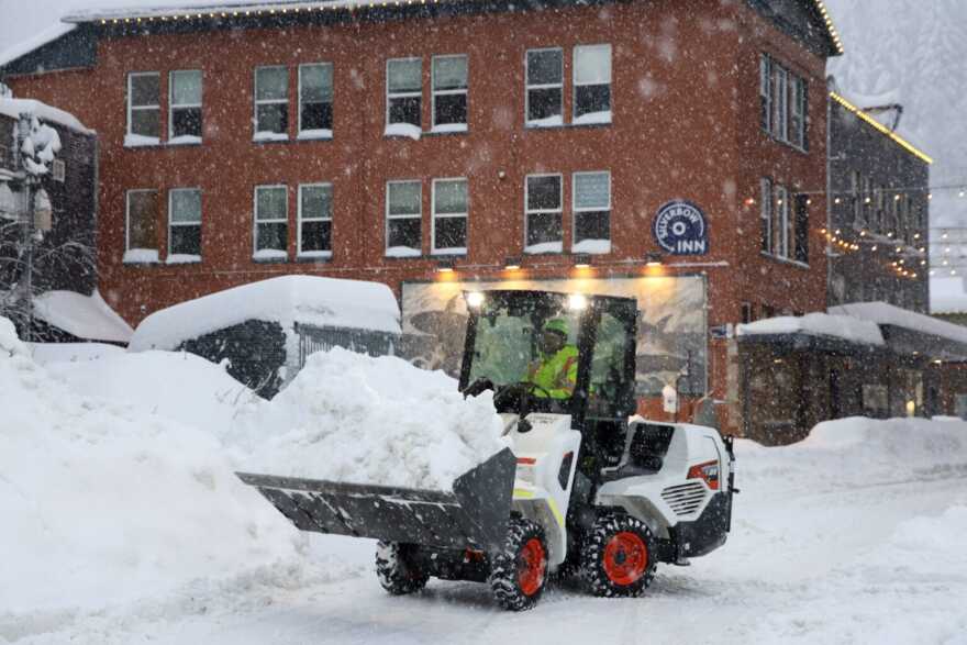 An operator scoops snow in downtown Juneau on Tuesday, Dec. 30, 2025.