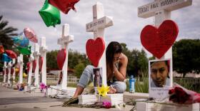 A woman writes a note on a cross for Eric Ivan Ortiz-Rivera at a memorial with wooden crosses for each of the 49 victims of the Pulse Nightclub, next to the Orlando Regional Medical Center, June 17, 2016 in Orlando, Florida. (Drew Angerer/Getty Images)