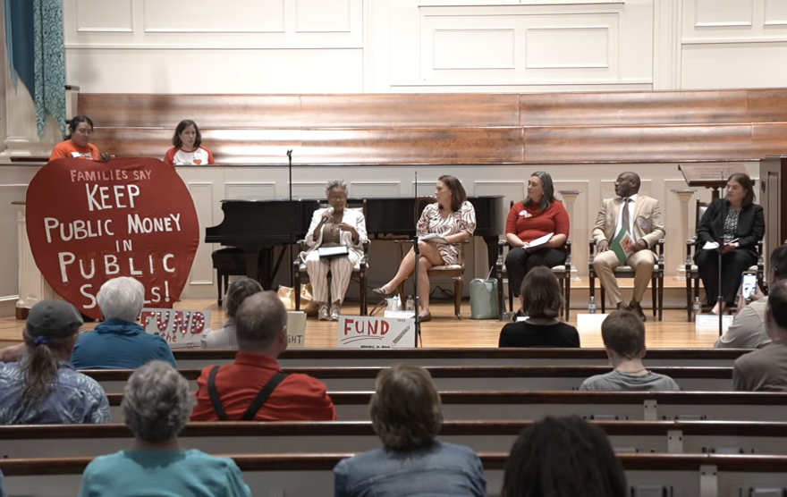 Guilford democratic representatives sit on stage at a town hall about public school funding