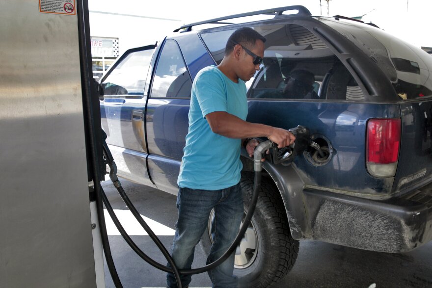 Richard Carrillo gases up his suburban in July 2016 in Juneau. Lawmakers decided against passing a bill this year that would triple the motor fuel tax. (Photo by Rashah McChesney/KTOO)