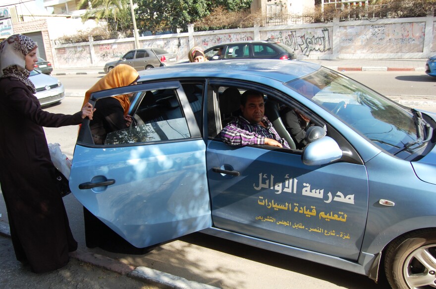 Students enter a car with instructor Abdel Nasser el-Bobbo in the passenger seat. To get around Hamas' recent crackdown on male instructors who are alone with female students, schools ask students to ride along with other learners.