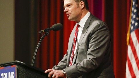 Kansas Secretary of State Kris Kobach supports Donald Trump during a rally in Wichita, Kan.