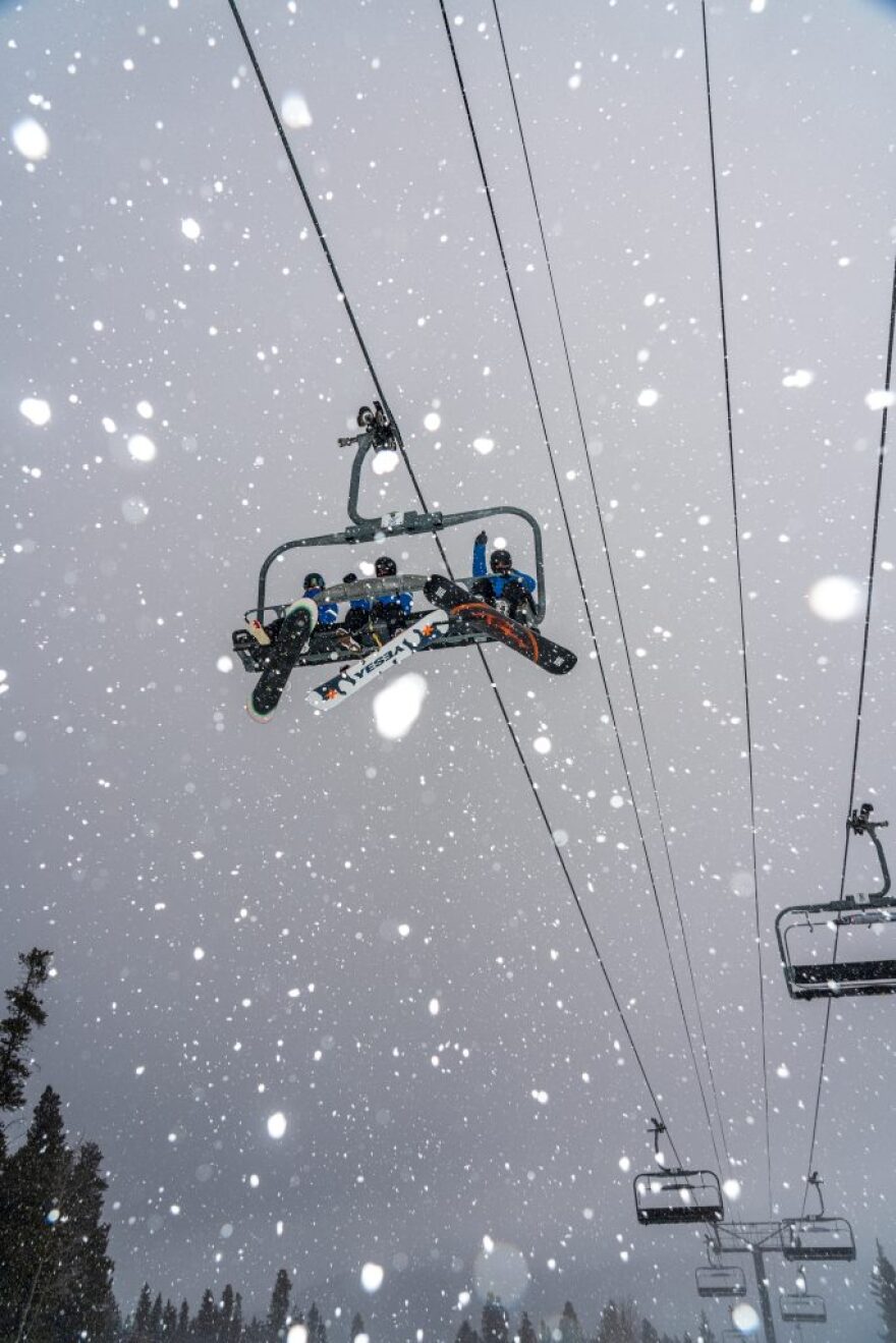 A group of snowboarders take a snowy chairlift ride up the mountain on Tuesday, Nov. 25, 2025.