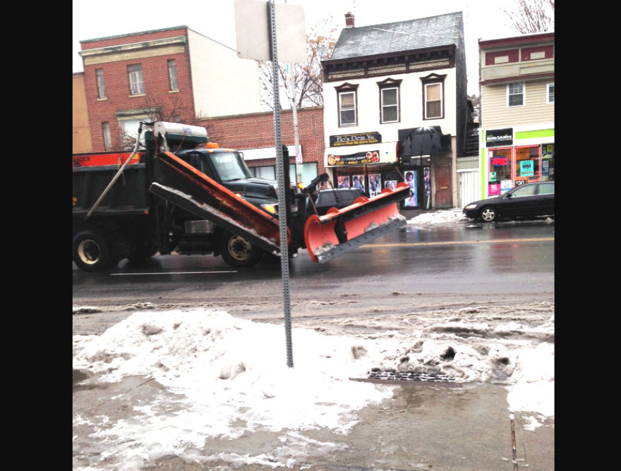 A snow plow cruises past the WAMC studios along Central Avenue in Albany.