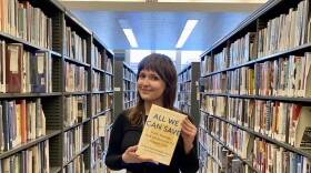 Kelly Bolter, a library services manager at the Milwaukee Public Library's central branch, holds up her March 2022 book recommendation, “All We can Save: Truth, Courage, and Solutions for the Climate Crisis”.