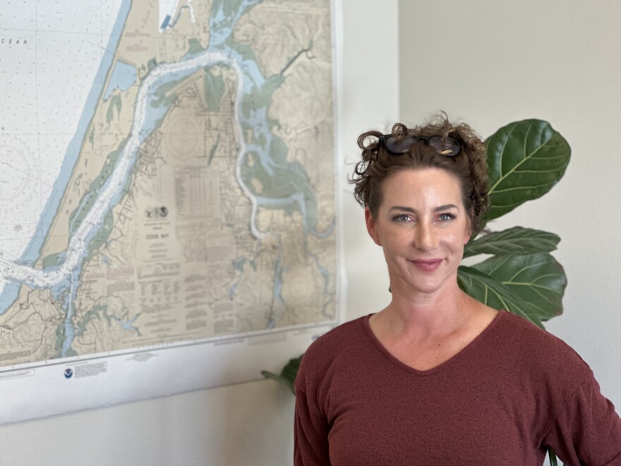 Woman in office, next to map.