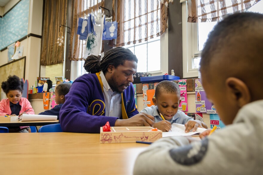 Meramec Elementary School Principal Jonathan Strong works with a preschool student on writing letters. Strong will have more flexibility next year to improve the St. Louis school.