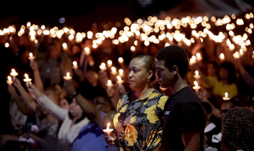Veronica Hartfield stands with her son Ayzayah Hartfield during a candlelight vigil for her husband, Las Vegas police officer Charleston Hartfield, Thursday, Oct. 5, 2017, in Las Vegas. Hartfield was killed during the shooting at the Route 91 Harvest country music festival.