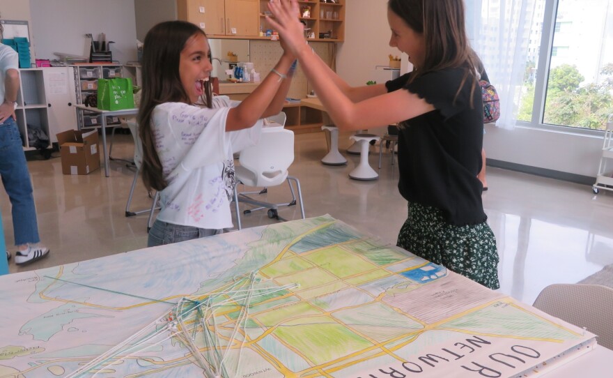 Students Eva O'Brien and Alana Contesse Quintero high-five to celebrate their accomplishments on their last day of fifth-grade.
