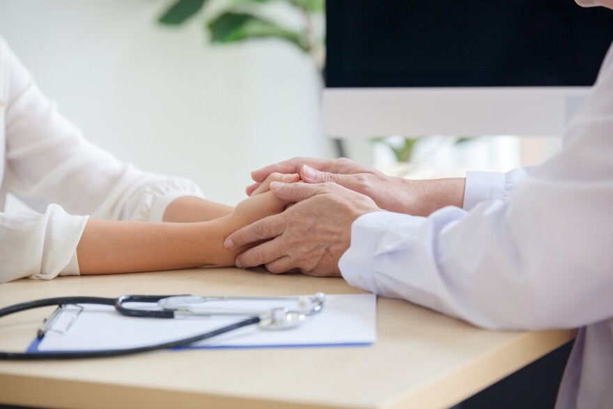 Hand of doctor reassuring her female patient. Medical ethics and trust concept