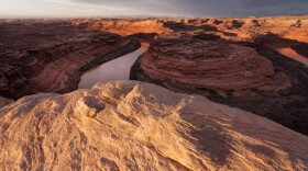 A winding river cuts through red rock canyons