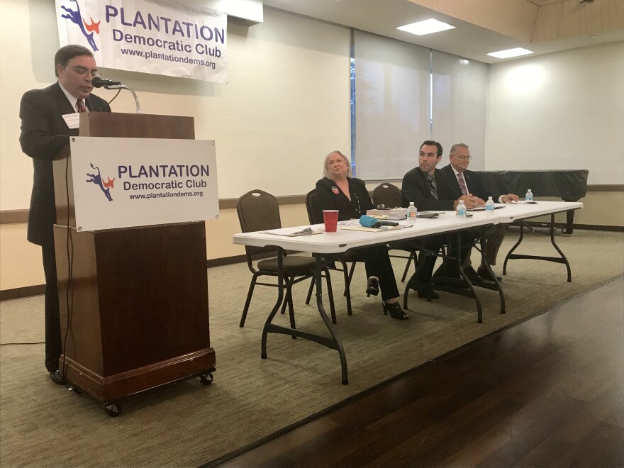 At the table are three of the five mayoral candidates: Lynn Stoner, Aron Davis, and Peter Tingom. 