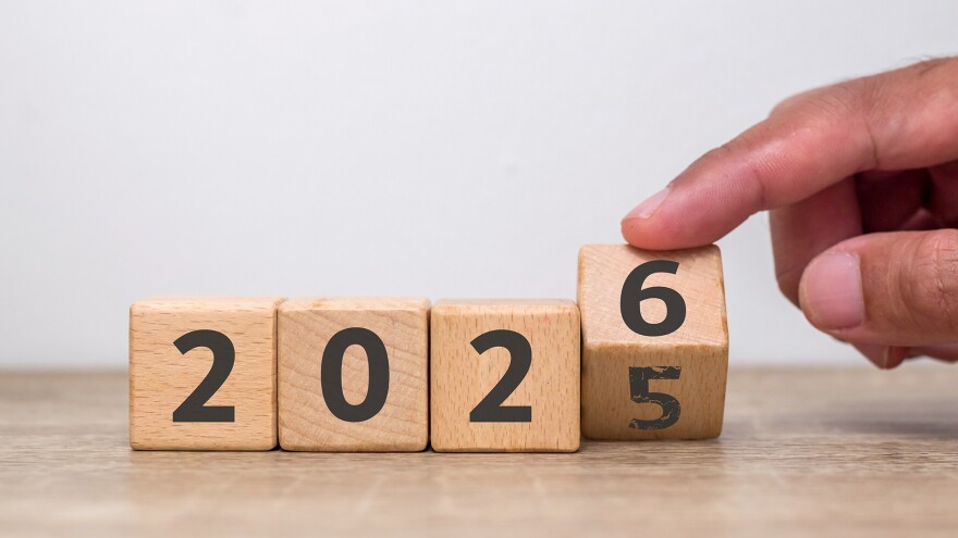 Hand flipping of 2025 to 2026 on wooden blocks with the number five already faded. Turn of the new year. New year's resolution.