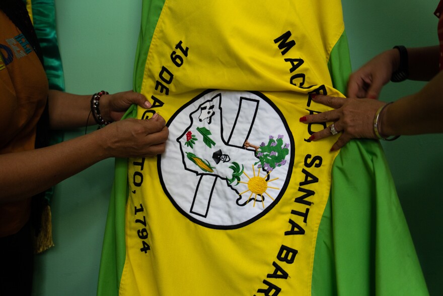 Jacqueline Trejo, Mayor of Macuelizo, ties up the town's flag in her office in City Hall.