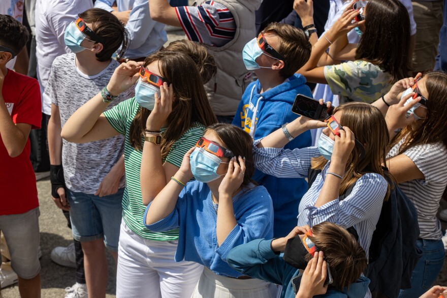 Students watch a partial eclipse in Roeselare, Belgium, on Thursday.