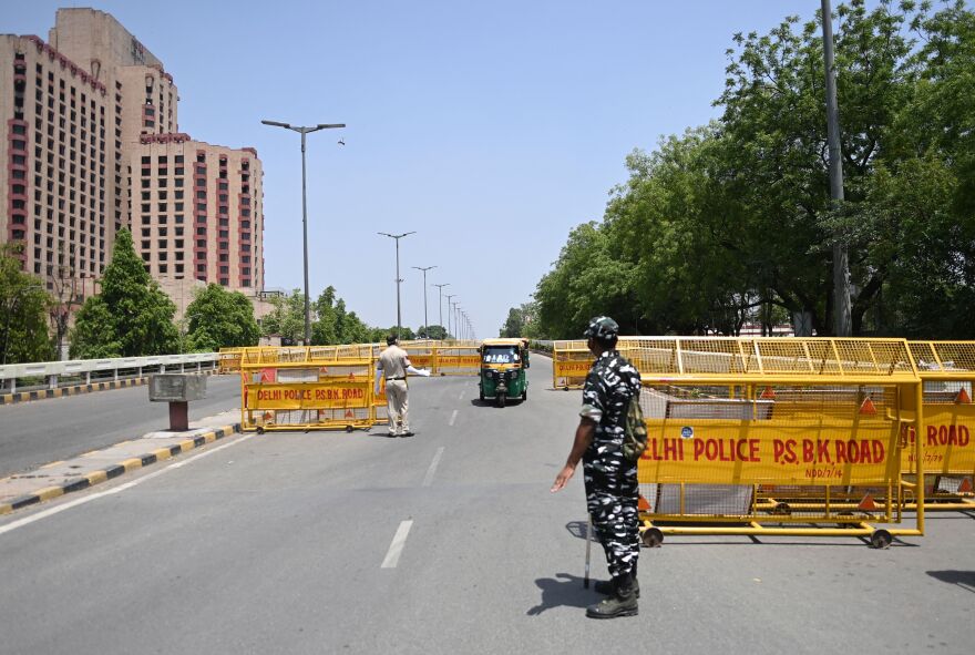 Police stop vehicles at a New Delhi checkpoint aimed at enforcing a weekend lockdown imposed by the government in the wake of rising COVID-19 cases.