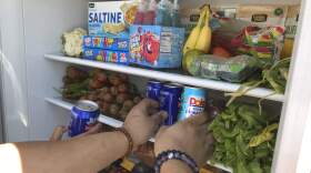 Volunteers stock a refrigerator with free food for people in need in Los Angeles. (Aron Ranen/AP)