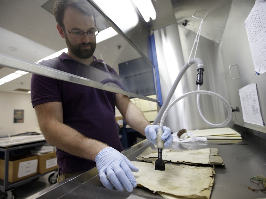 Patrick Brown, a conservation technician, works on Iraqi Jewish documents at the National Archives in College Park, Md., on Sept. 30.