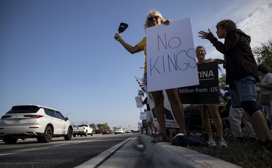 Protesters line U.S. 41 near Daniels Parkway on Saturday, March 28, 2026, for the No Kings rally.
