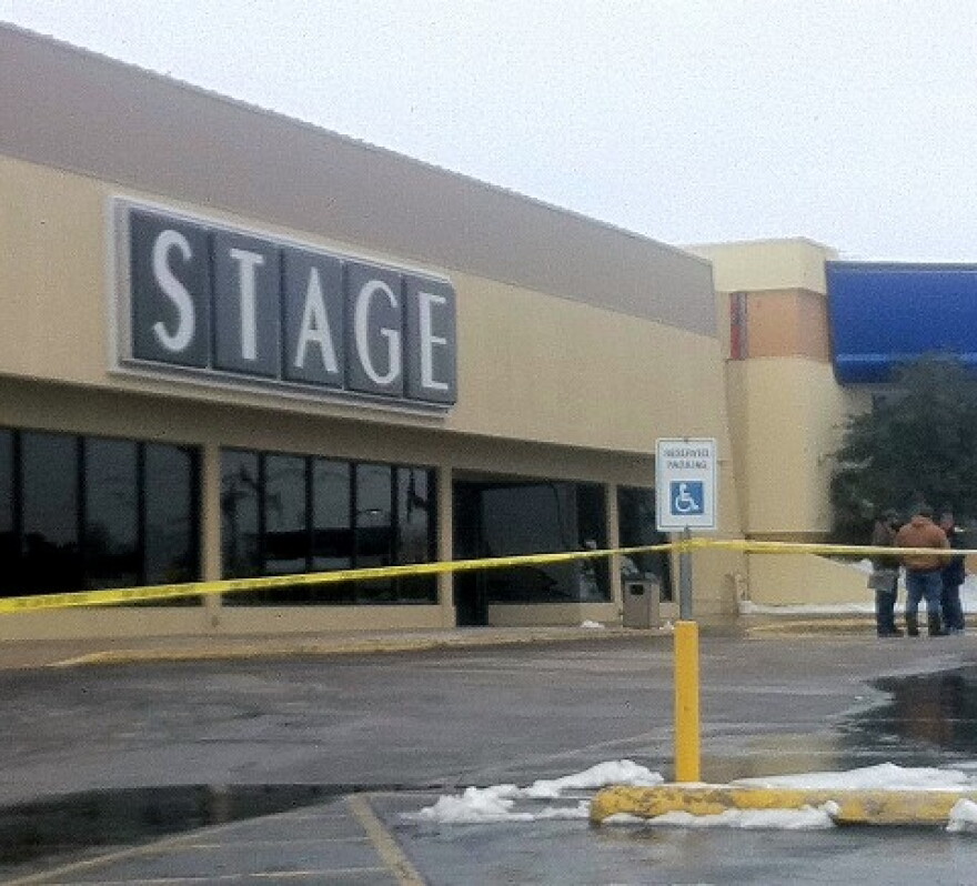 With the parking lot blocked-off, workers survey the damage at the Broken Arrow Stage store.