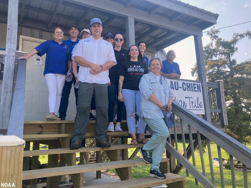 Representatives from NOAA and Louisiana Sea Grant and Pointe-au-Chien tribe members pose for a photo outside of the tribal building. They all met to discuss the tribe's priorities for resilience and adaptation in the face of climate change and shifting coastline.