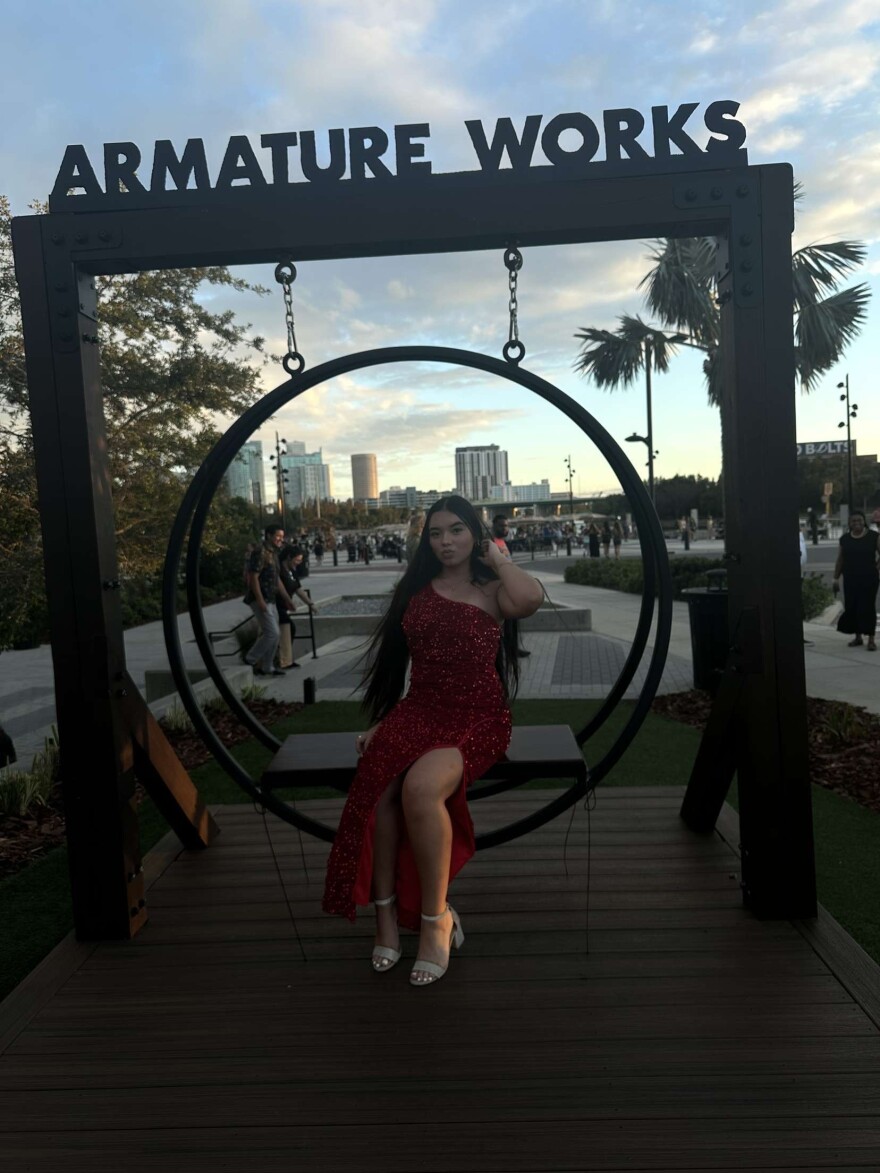 A teenage girl poses under a sign that says Armature Works at the Tampa entertainment area