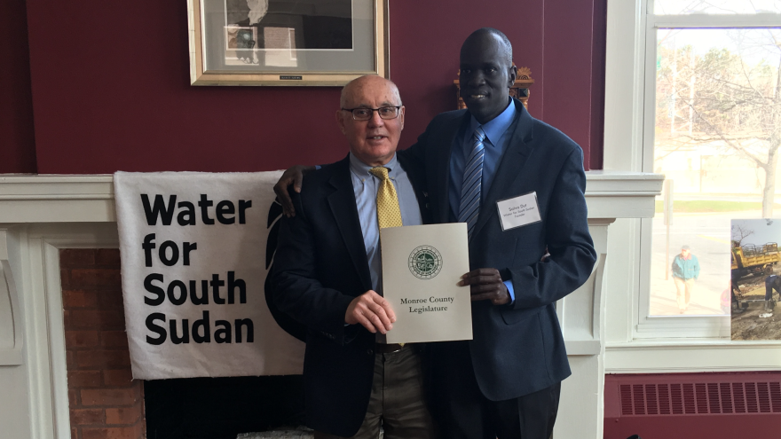 Monroe County Legislator Frank Allkofer delivers a proclamation to Salva Dut on behalf of Monroe County for his service to the community, and to South Sudan.