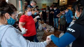 Volunteers and members of the Chelsea Collaborative Inc. pray before distributing food and packages of donated goods to people in need at the Pan Y Cafe in Chelsea, Massachusetts.
