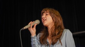 Ava Preston sings in studio holding a microphone