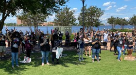 Photo by Sam Turken/WHRO. Attendees at a Norfolk Juneteenth rally hold their fists up in solidarity for racial justice.