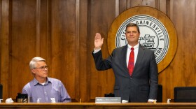 Gainesville Regional Utilities board member Eric Lawson, right, is sworn in to office during the GRU Authority board’s first meeting at the City Commission building in Gainesville, Florida Oct. 4, 2023. (Gabriel Velasquez Neira/WUFT News) (edited